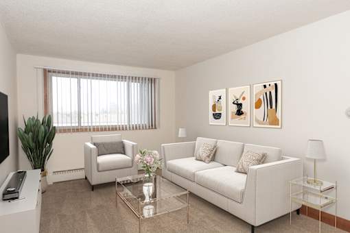 A living room with a white couch, a glass coffee table, and a television.