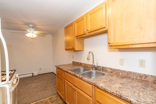 A kitchen with wooden cabinets and granite countertops.