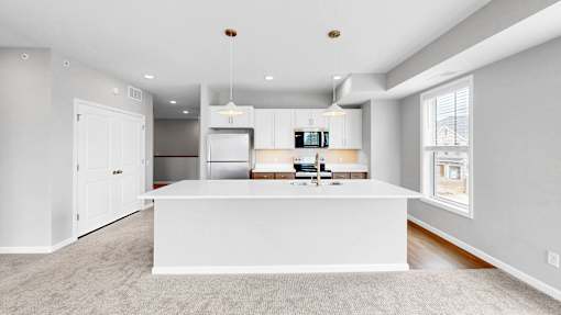 A modern kitchen with a white island in the middle.