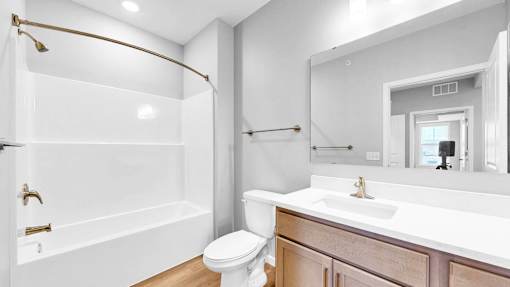A white bathroom with a toilet, sink, and bathtub.