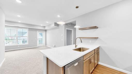 A kitchen with a white countertop and wooden cabinets.