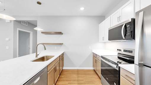 A modern kitchen with stainless steel appliances and wooden cabinets.