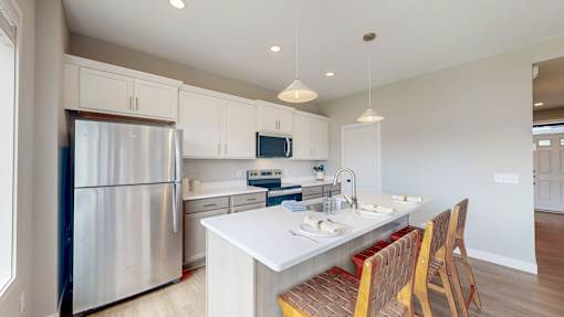 A modern kitchen with a stainless steel refrigerator and a white countertop.