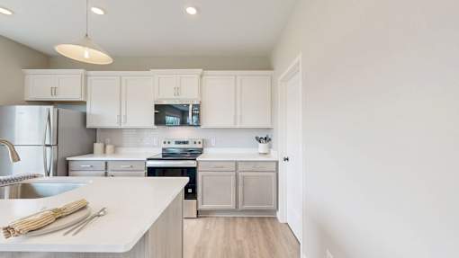 A kitchen with white cabinets and a white countertop.