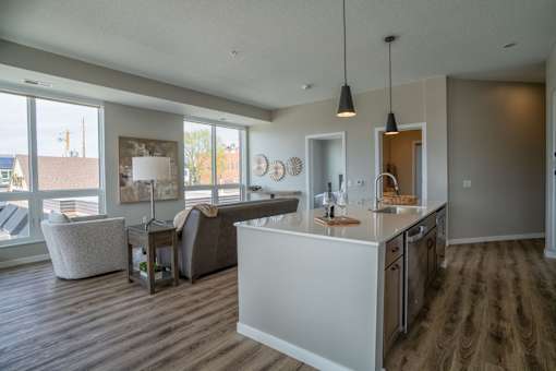 A modern kitchen with a white island and stainless steel appliances.
