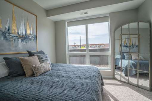 A bedroom with a large bed and a painting on the wall.