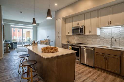 A kitchen with a white counter top and wooden cabinets.