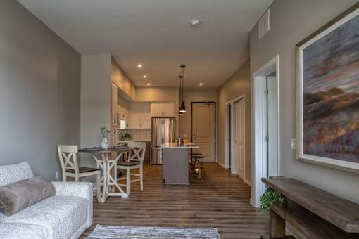 A living room with a couch, chairs, and a dining table.