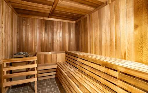 A wooden sauna with benches and a tiled floor.