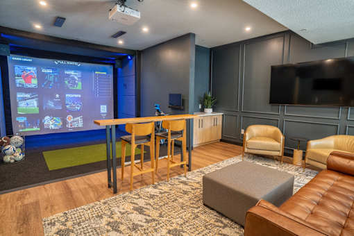A modern living room with a large screen and comfortable seating.