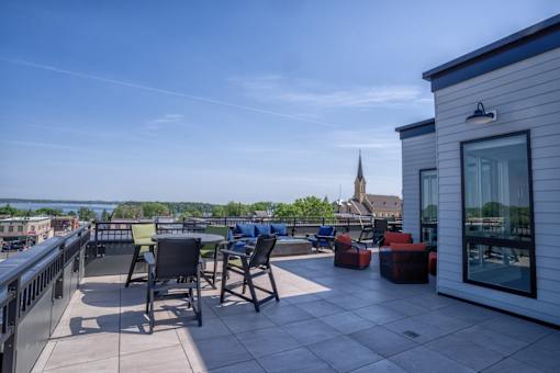 A patio with chairs and a table overlooking a cityscape.