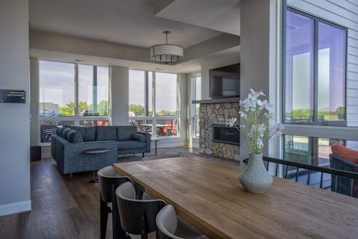 A modern living room with a wooden table and grey couches.