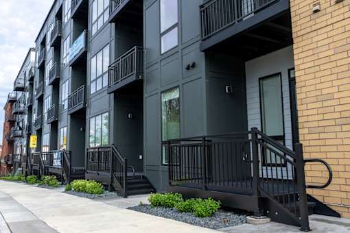 A black building with a balcony and a door.