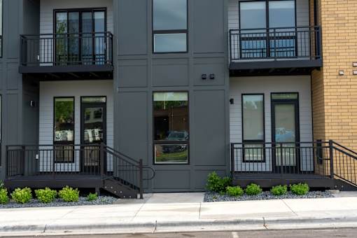 A modern two-story building with black railings and windows.