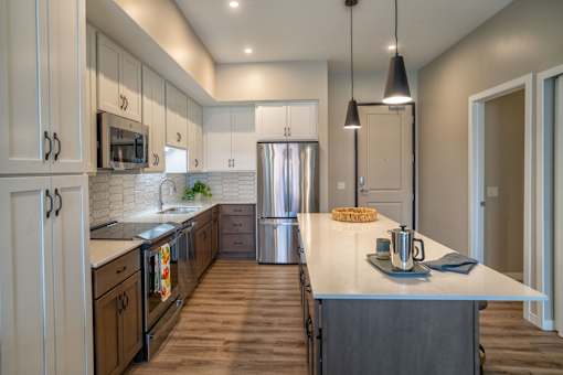 A modern kitchen with wooden cabinets and a stainless steel refrigerator.
