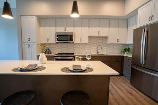 A kitchen with a white countertop and stainless steel appliances.
