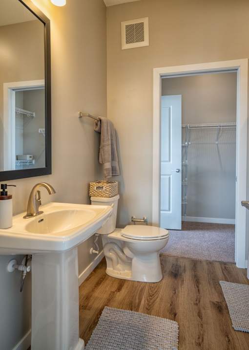 A white toilet sits in a bathroom next to a white sink.