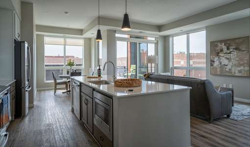 A modern kitchen with a large island and a view of the city.