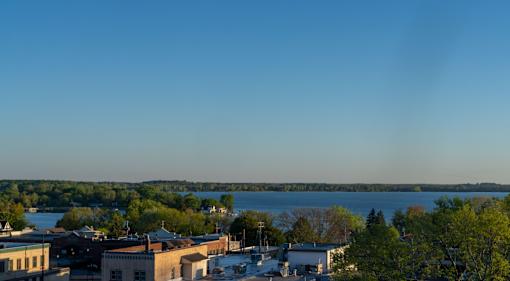 A cityscape with buildings and a body of water in the distance.