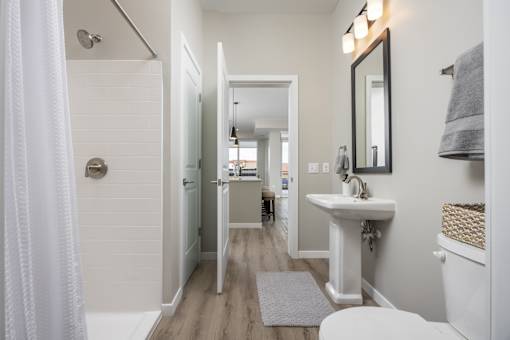 A white bathroom with a white sink and a white toilet.