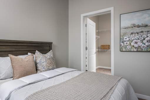 A bedroom with a large bed and a painting on the wall.