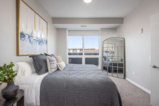 A bedroom with a large bed and a painting on the wall.