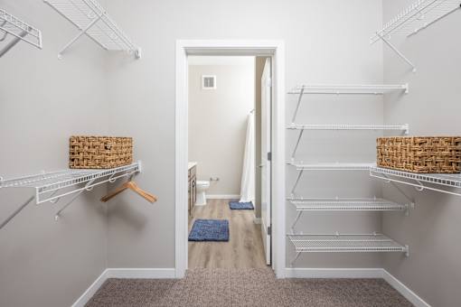 A hallway with a doorway leading to a bathroom and a carpet on the floor.