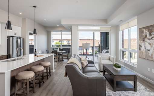 A modern living room with a bar area and a view of the outdoors.