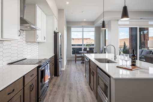 A modern kitchen with dark wood cabinets and a white countertop.