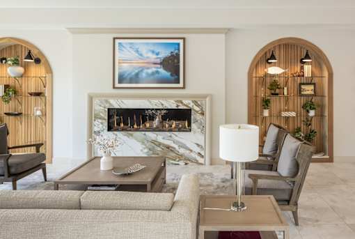 A living room with a fireplace and a painting above it.