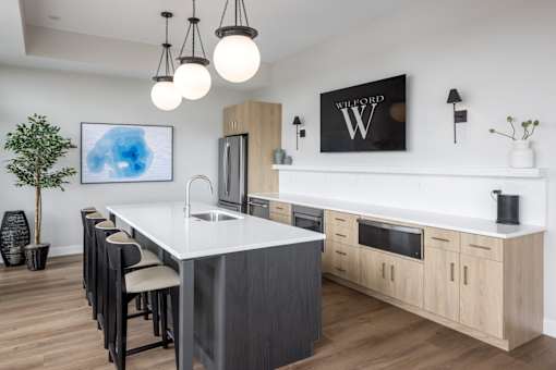 A modern kitchen with a white island and wooden cabinets.