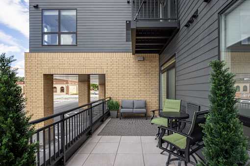 A balcony with a table and chairs overlooking a street.