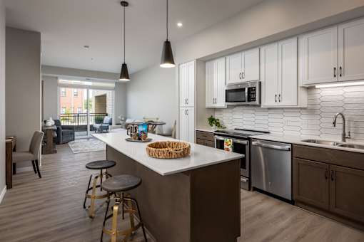 A kitchen with a white countertop and a bar stool.