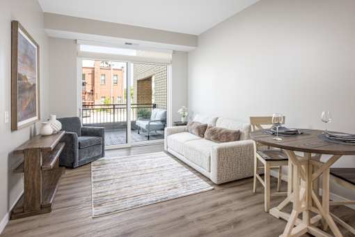 A living room with a couch, chair, and dining table.