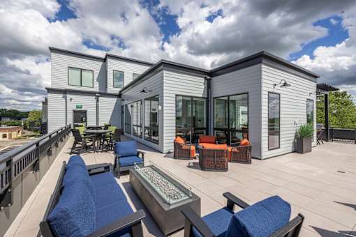 A modern house with a deck and patio furniture.