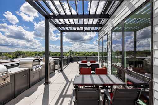 A patio with a table and chairs is covered by a roof.
