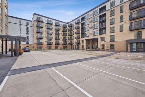an empty parking lot in front of an apartment building