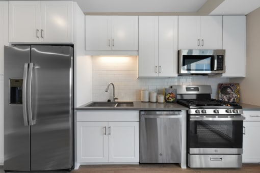 a kitchen with stainless steel appliances and white cabinets