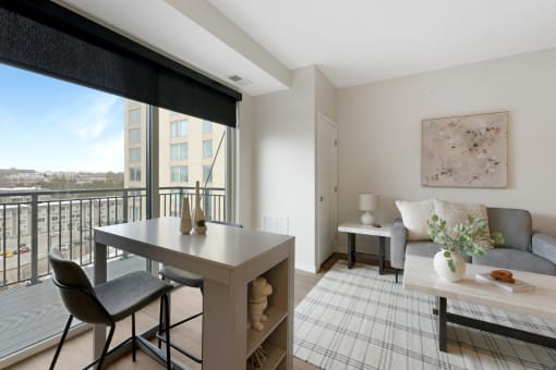 a living room with a table and a couch and a balcony