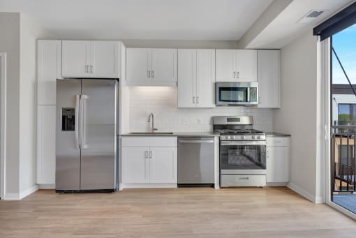 a kitchen with white cabinets and stainless steel appliances