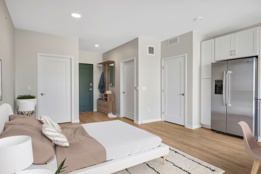 a bedroom with a bed and a refrigerator