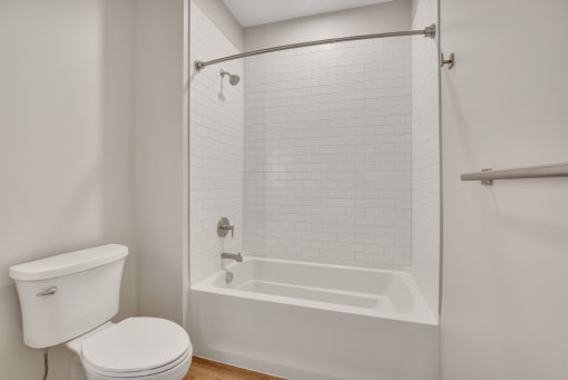 a bathroom with a white toilet and a white tub with a shower curtain
