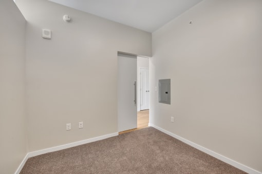 a bedroom with grey carpet and white walls
