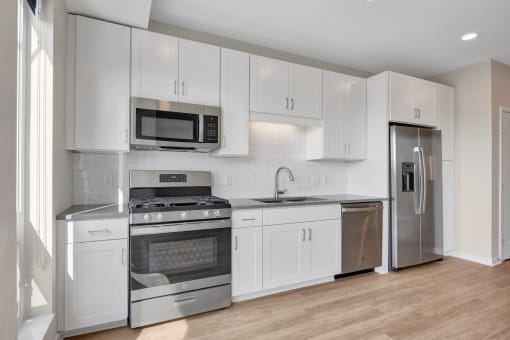 a kitchen with white cabinetry and stainless steel appliances