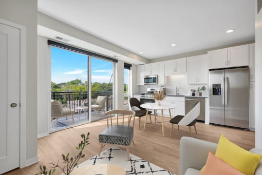 a living room and kitchen with a sliding glass door that leads to a balcony