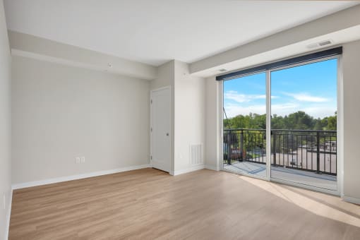 a bedroom with a sliding glass door and hardwood floors