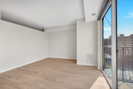 a bedroom with a large window and hardwood floors