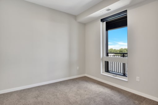 a bedroom with a large window and carpet