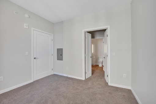 a bedroom with grey carpet and white walls