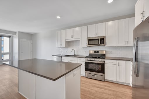 a kitchen with white cabinets and stainless steel appliances
